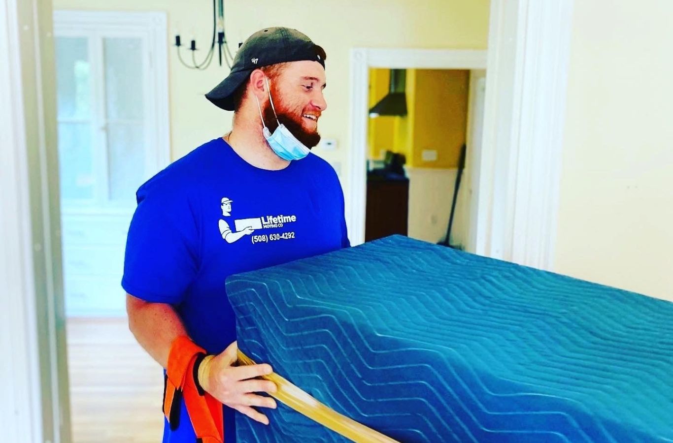 A Lifetime Moving Co team member secures packed boxes in a Watertown, MA home, showing efficiency, safety, and care during the move.